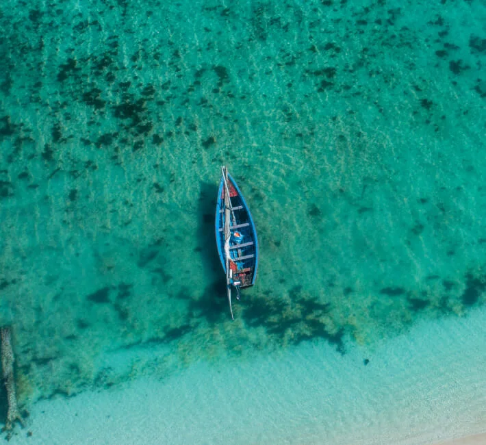 Aerial view of a small boat floating on the blue ocean